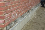 West wall with stone veneer, foundation flashing, weep holes and double wythe brick wall
