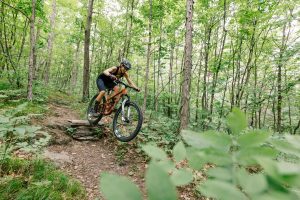 Photograph of Caitrin Maloney taking flight on one of the many built features on Freefall in the Slate Valley Trails